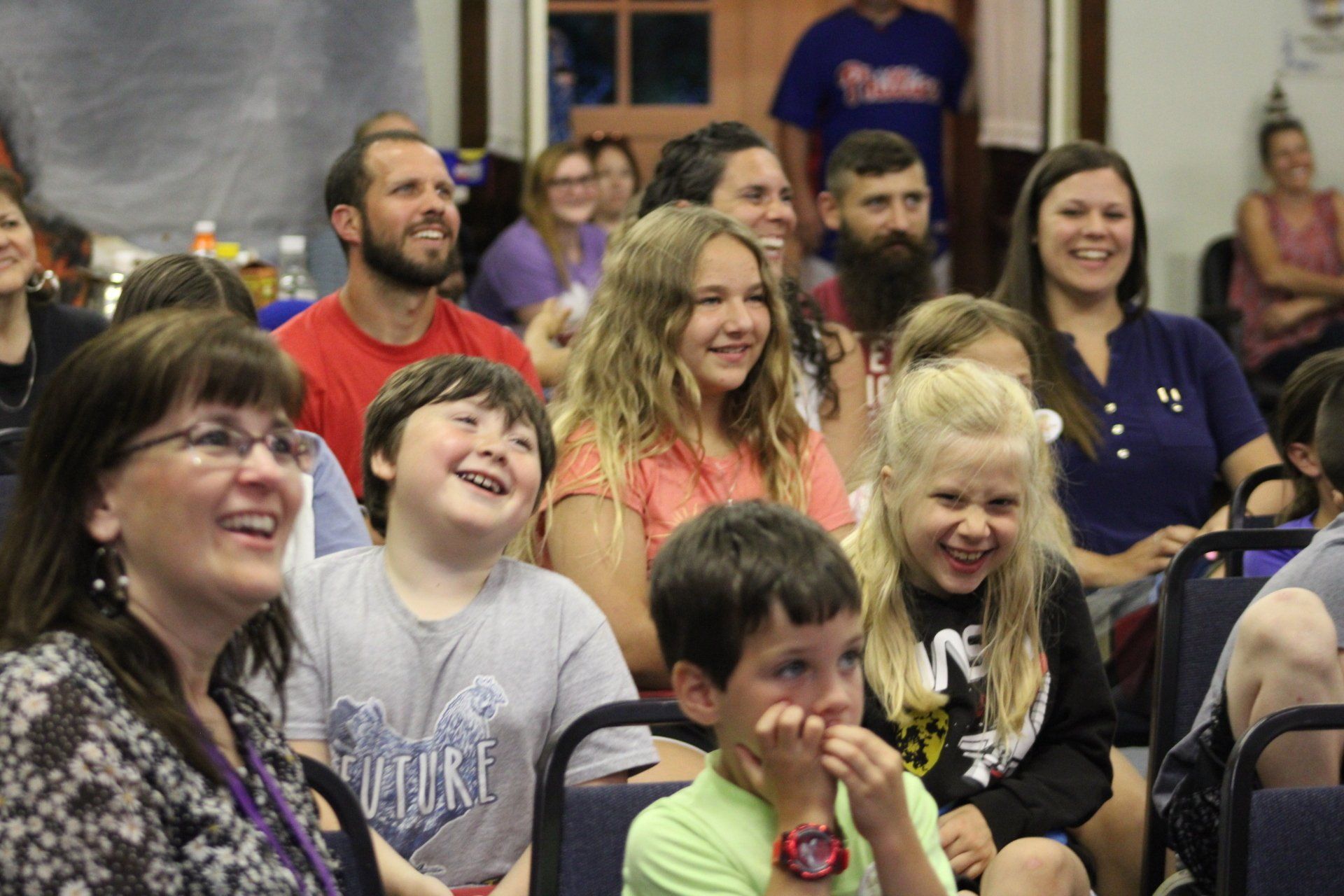 A group of people are sitting in a room and laughing.