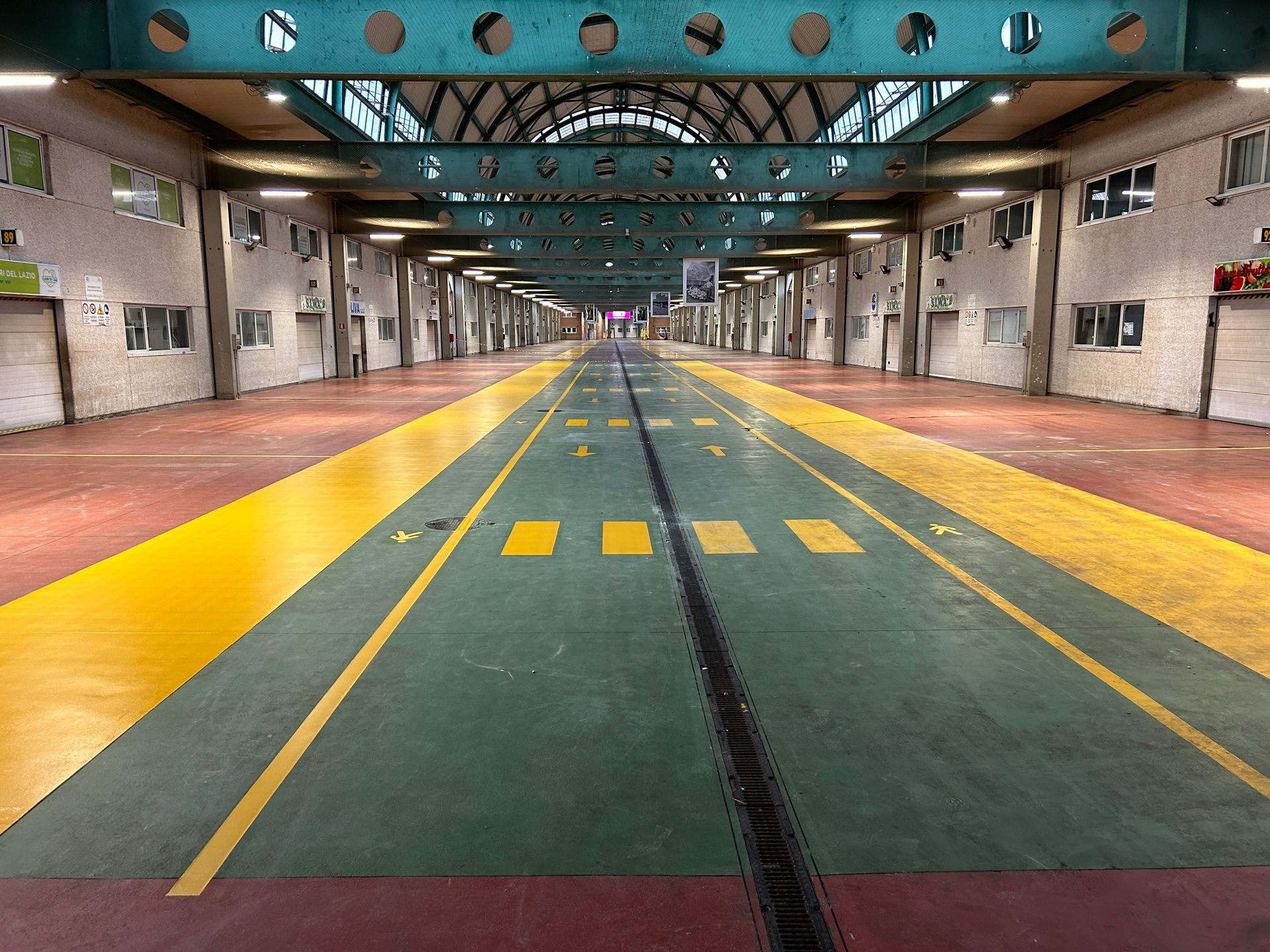 Una persona che aziona una sabbiatrice blu su un pavimento di cemento, rimuovendo del materiale da una stanza.