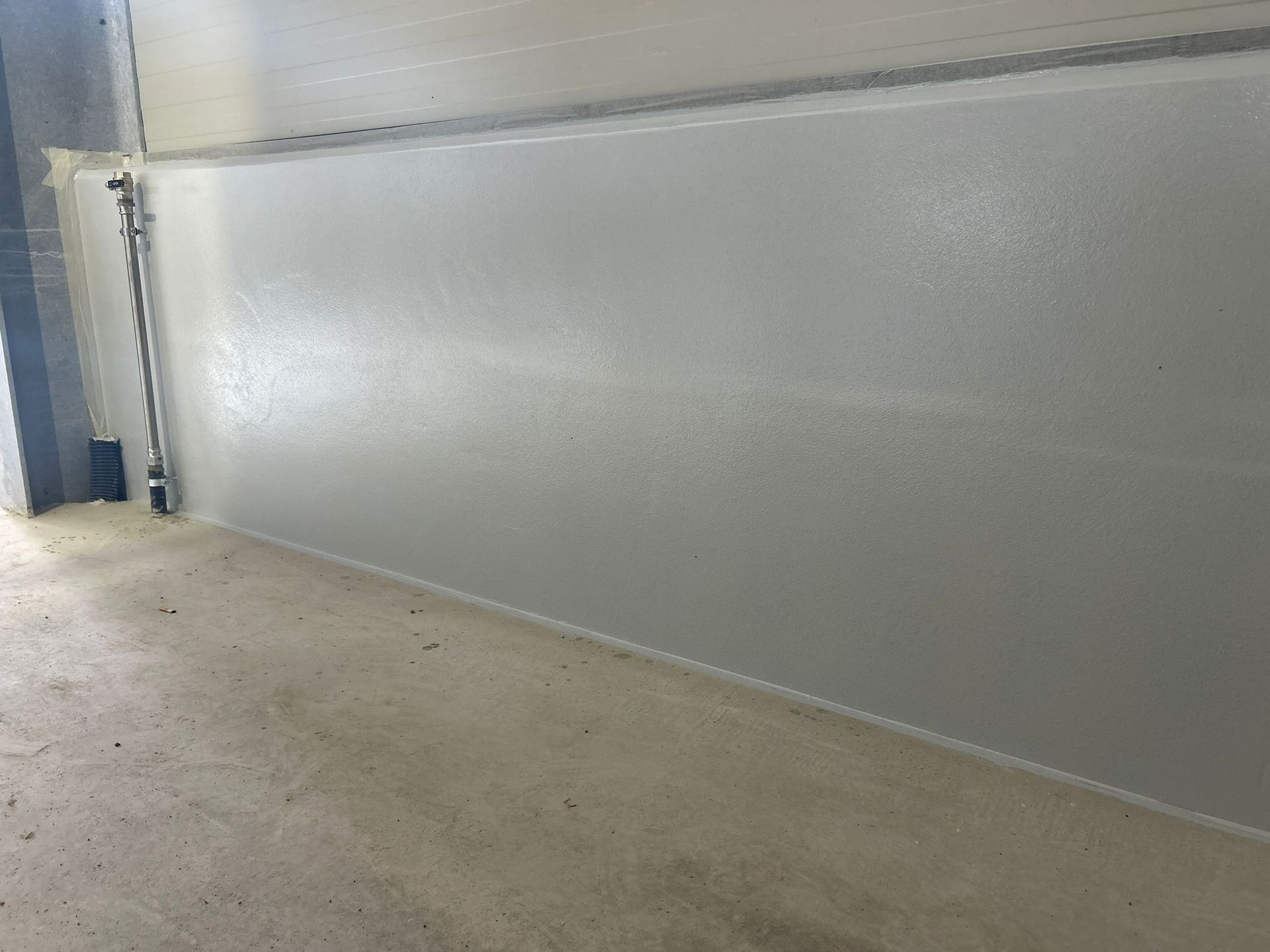 Grandi tini rivestiti in rame in un caseificio, pronti per la lavorazione del latte. Toni del grigio e del beige.