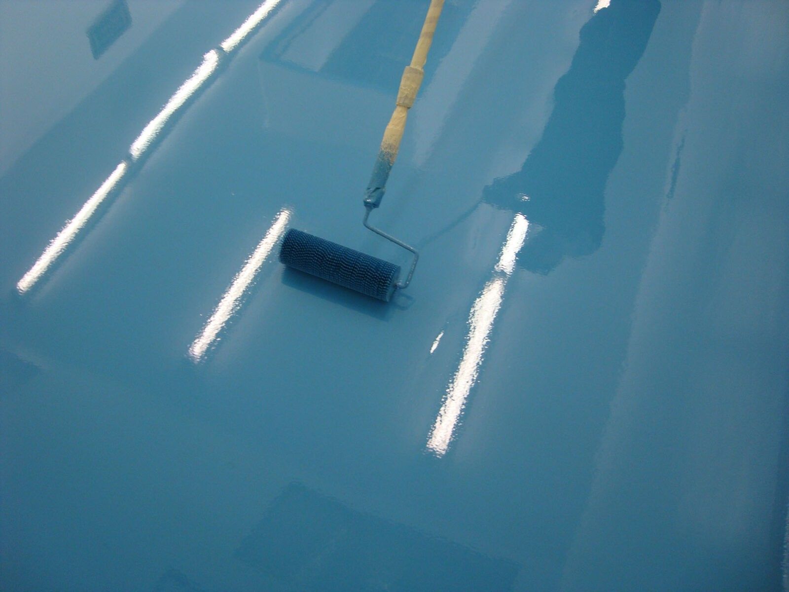 Superficie dipinta di blu passata con un rullo.