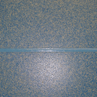 Piastrelle maculate di colore azzurro chiaro con una fuga di colore azzurro più chiaro che corre orizzontalmente al centro.