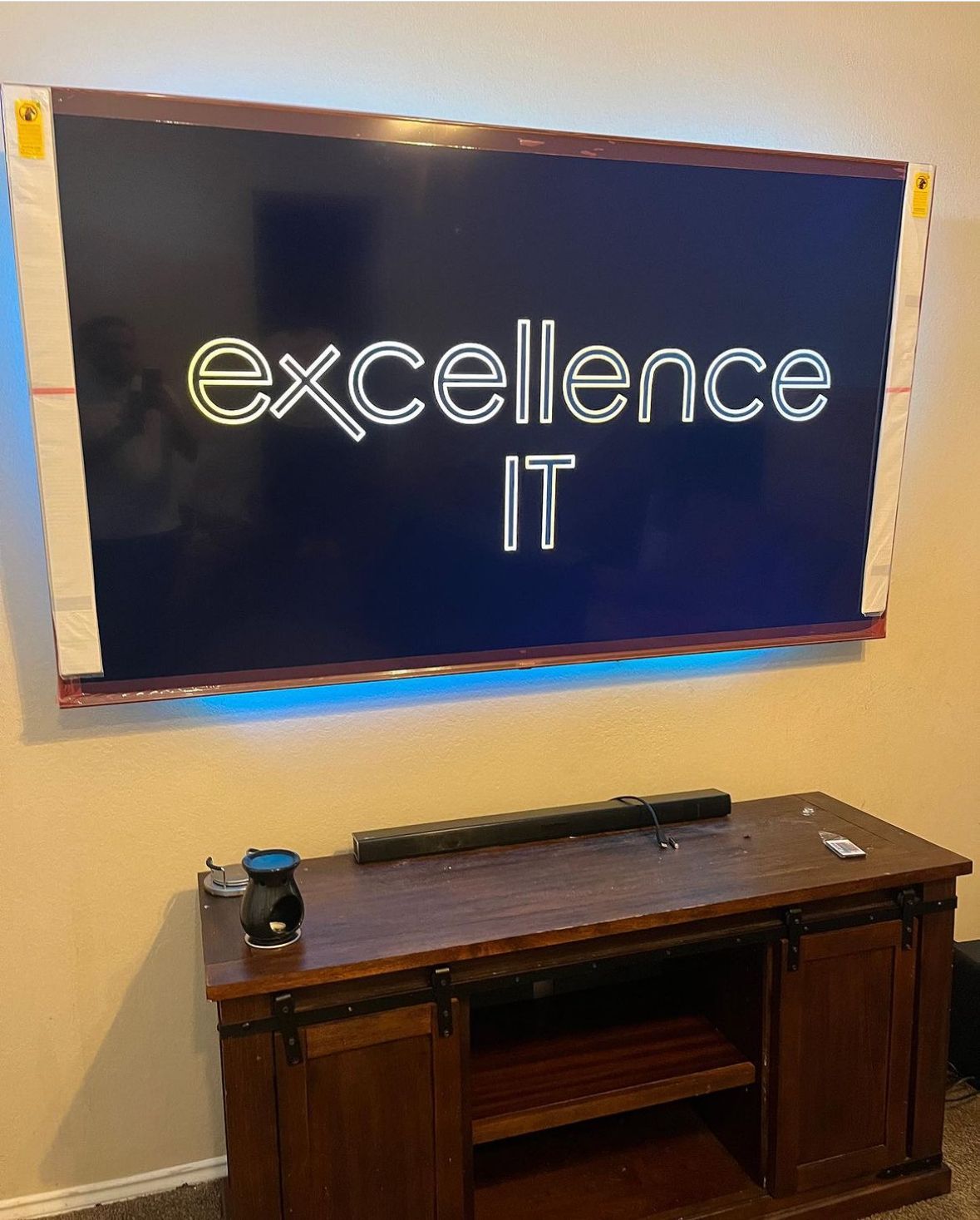 A flat screen tv is mounted on a wall above a wooden entertainment center.