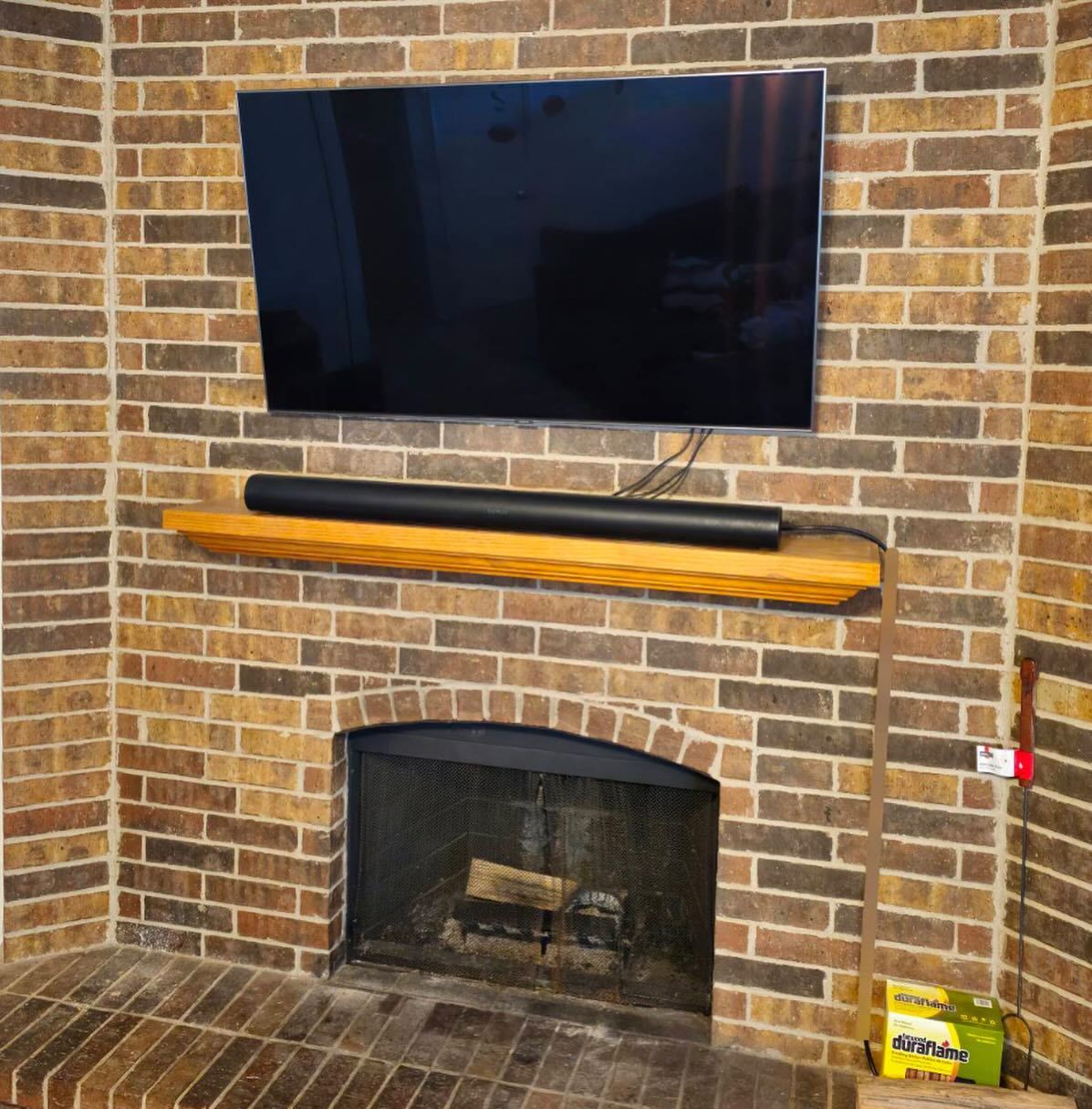 A brick fireplace with a flat screen tv above it