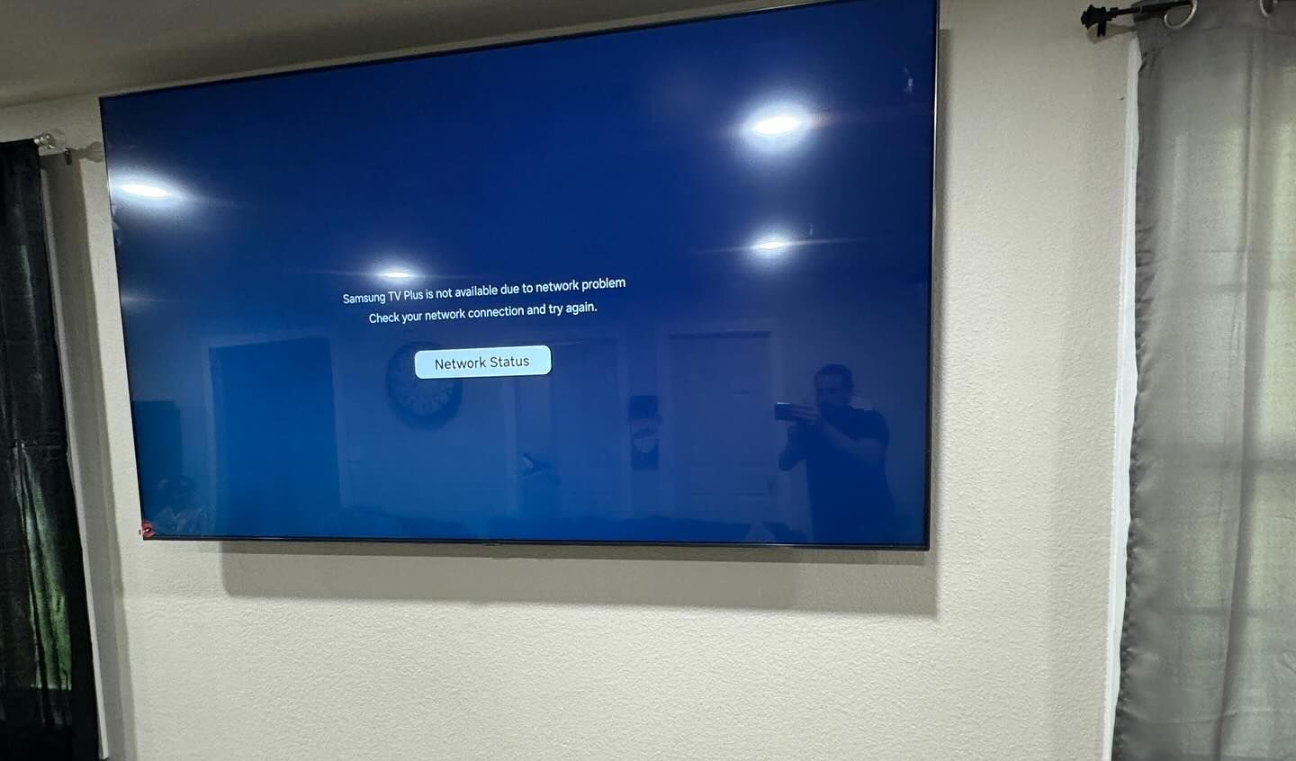 A flat screen tv is hanging on a wall in a living room.