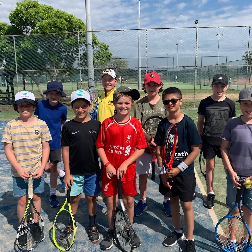 A Group of Young Boys Holding Tennis Rackets on a Tennis Court — Topspin Tennis Newcastle in Lambton, NSW