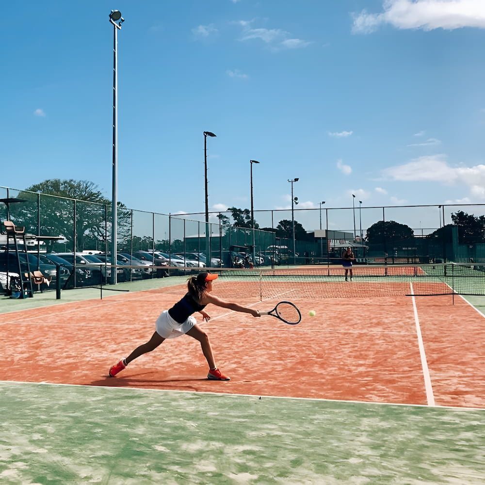 A Woman is Playing Tennis on a Court — Topspin Tennis Newcastle in Lambton, NSW
