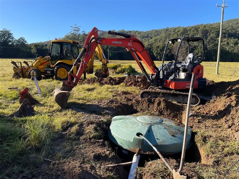 A Man Is Using An Excavator — Tim Larkin Plumbing and Excavations in Laurieton, NSW