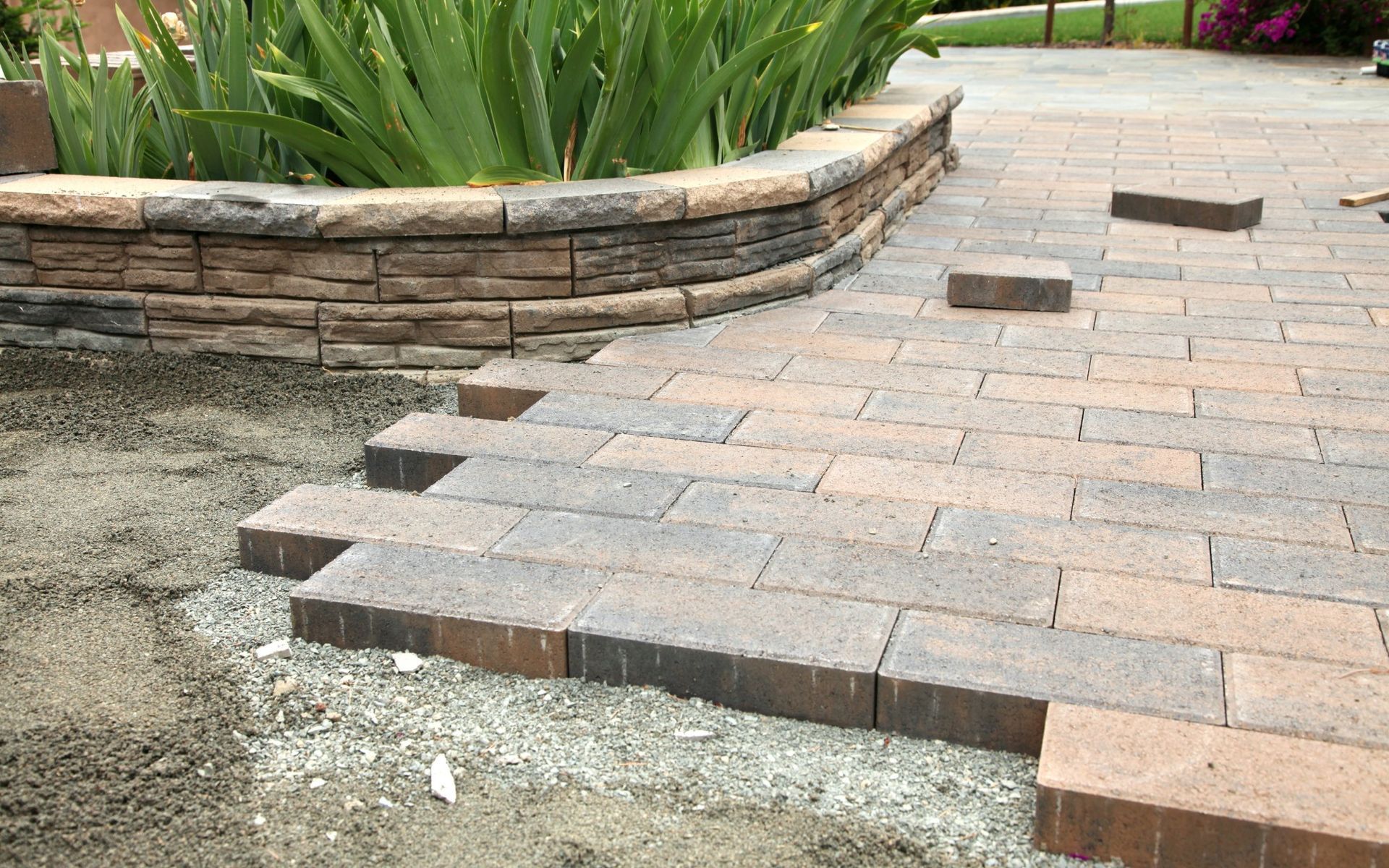 landscape paver edging is installed to divide the garden and the paved patio