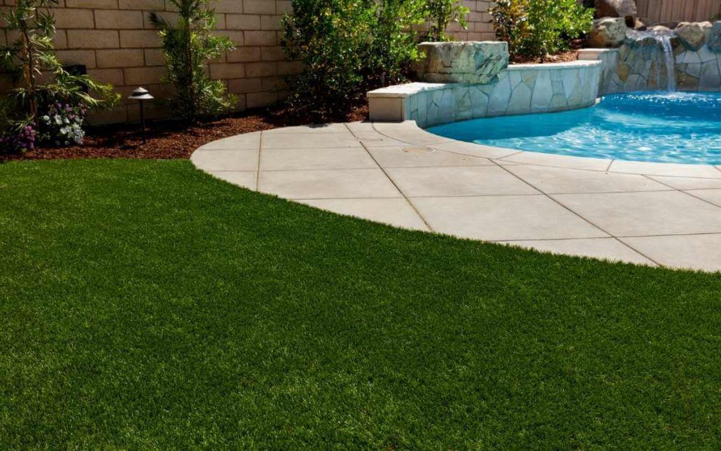 The pool, the pavers, and the artificial turf  side by side create an attractive landscape
