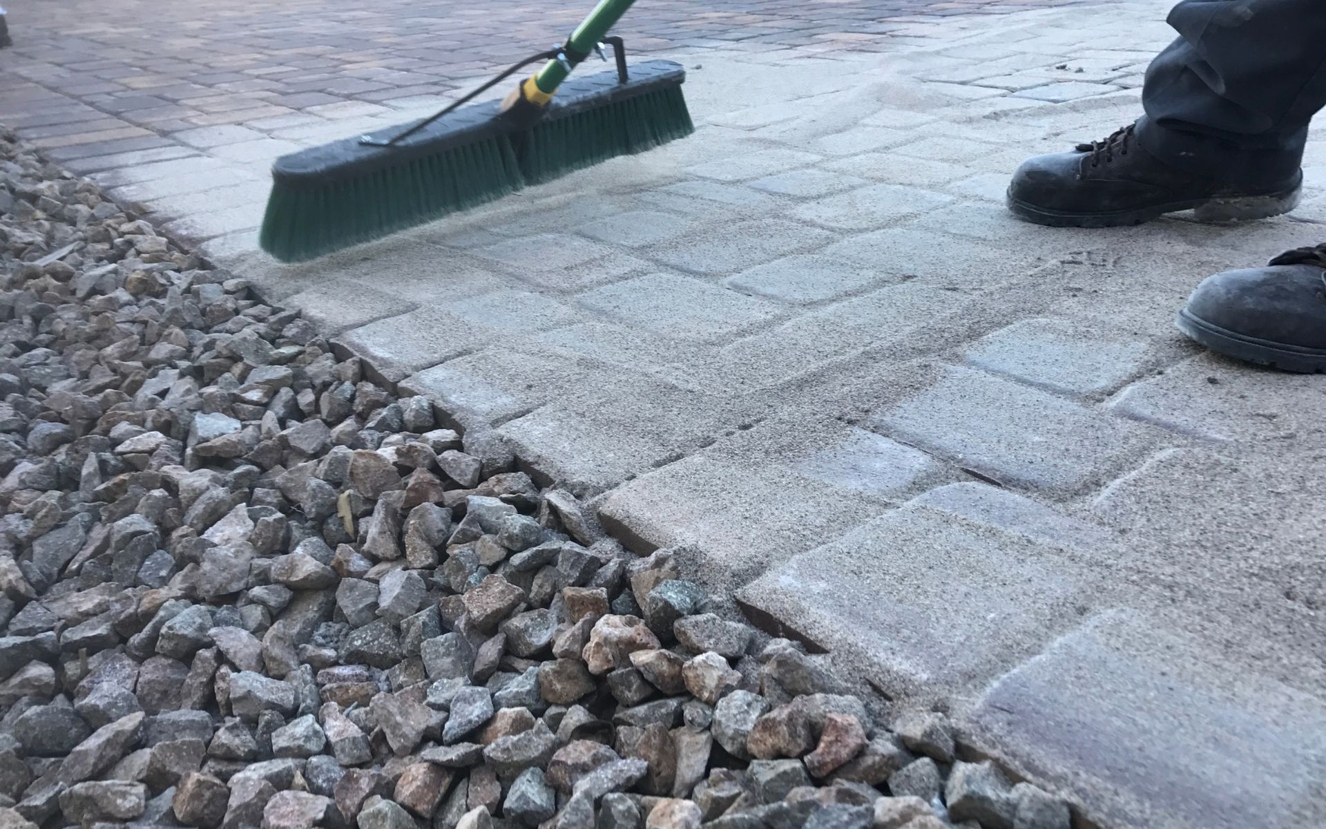 polymeric sand in spread all over the newly installed pavers