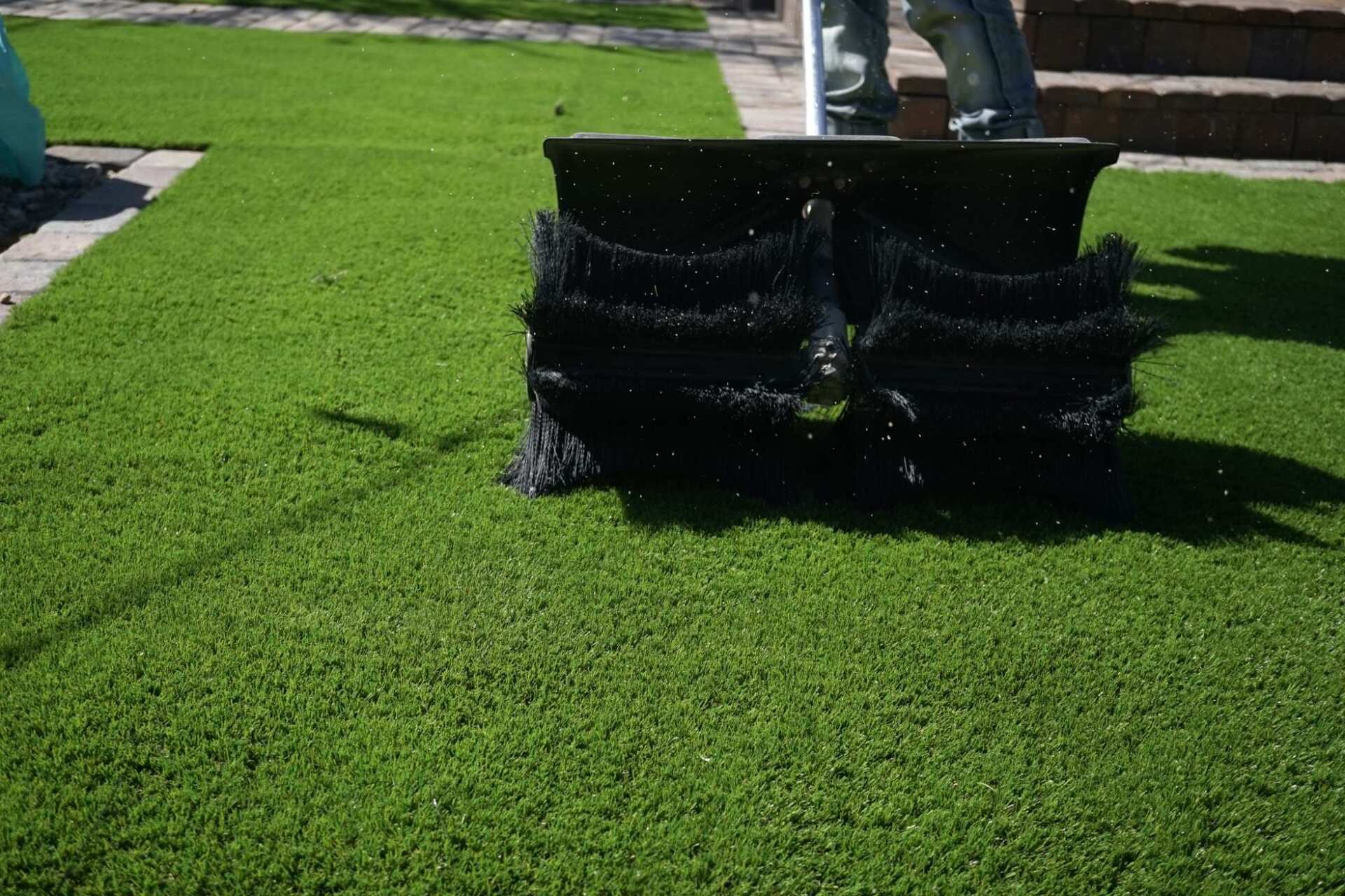 this power broom is used to remove debris from this newly installed artificial grass
