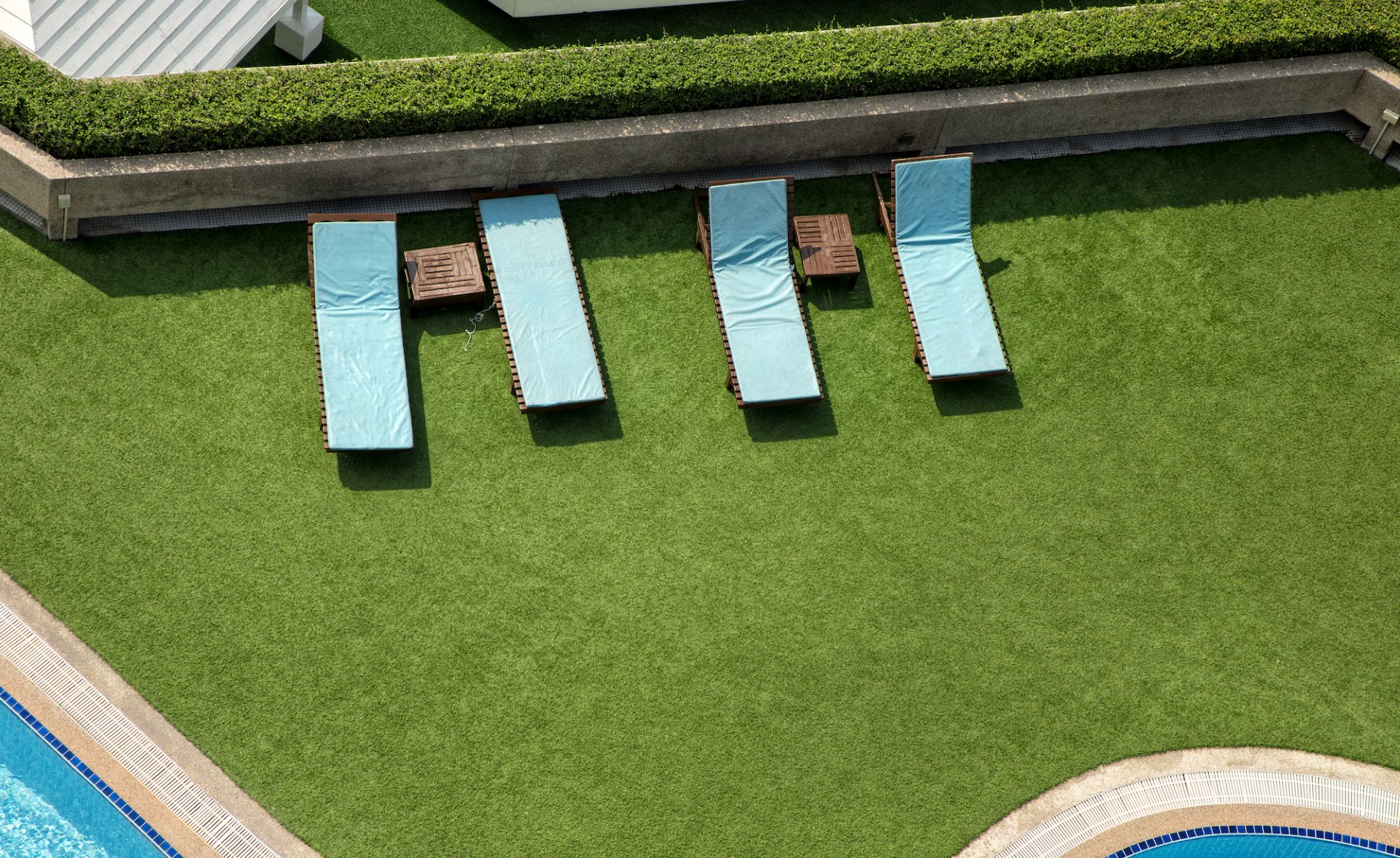 loungers around an artificial grass pool deck