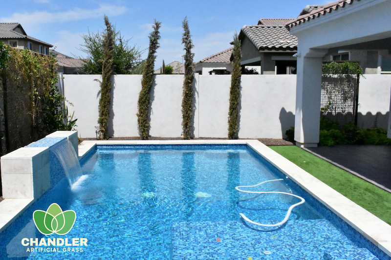 blue tiled pool with artificial grass around the edges