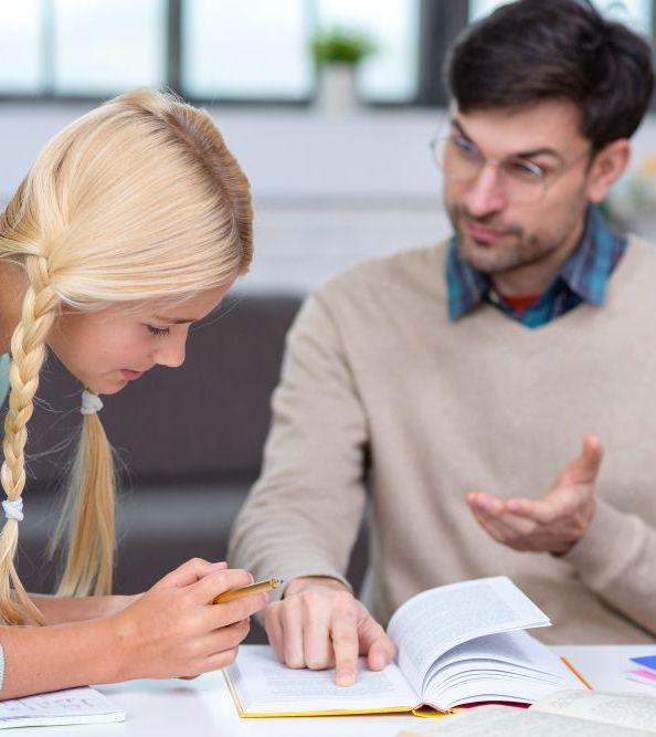 Young girl being taught by a teacher