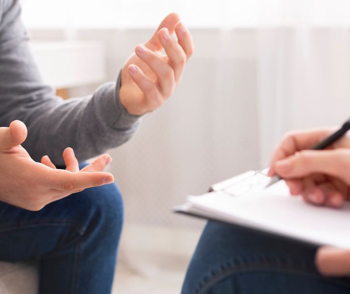 Zoomed image of a hand holding a yelow tablet