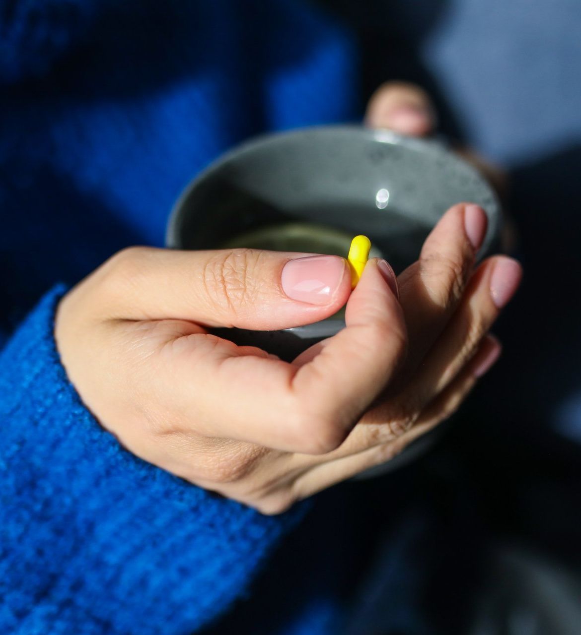 Zoomed image of a hand holding a yelow tablet