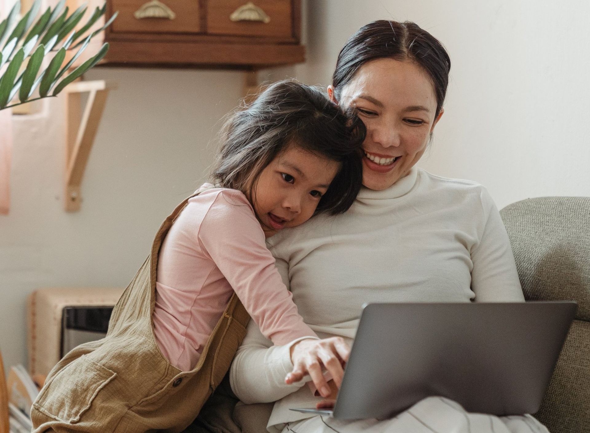 Family sat smiling using a computer