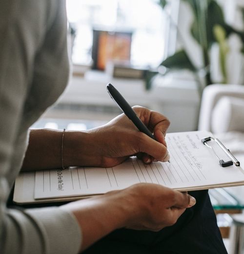 Woman writing notes on her clipboard