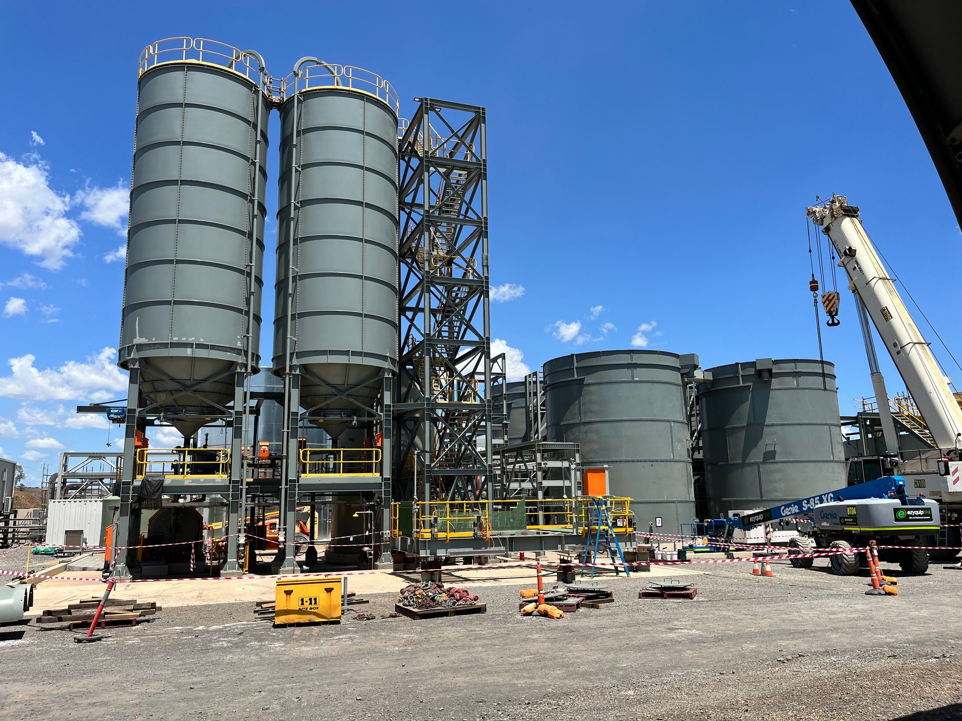 A construction site with silos and a crane in the foreground — Calibre Engineering In Mica Creak, QLD
