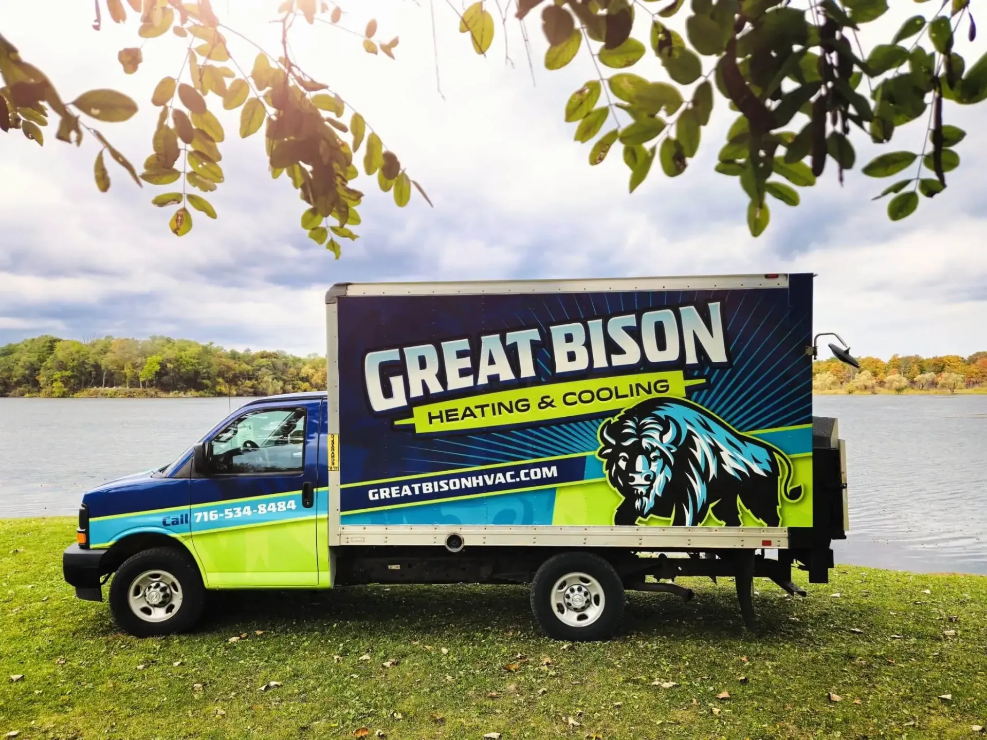 A great bison truck is parked next to a body of water.