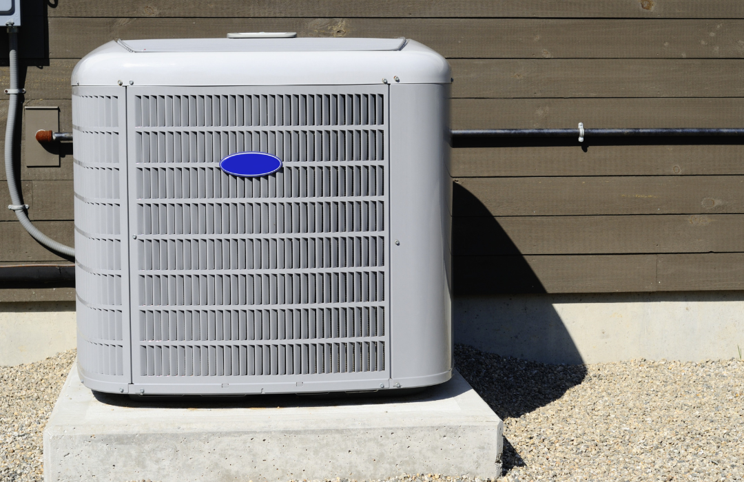 A carrier air conditioner is sitting on top of a concrete block.