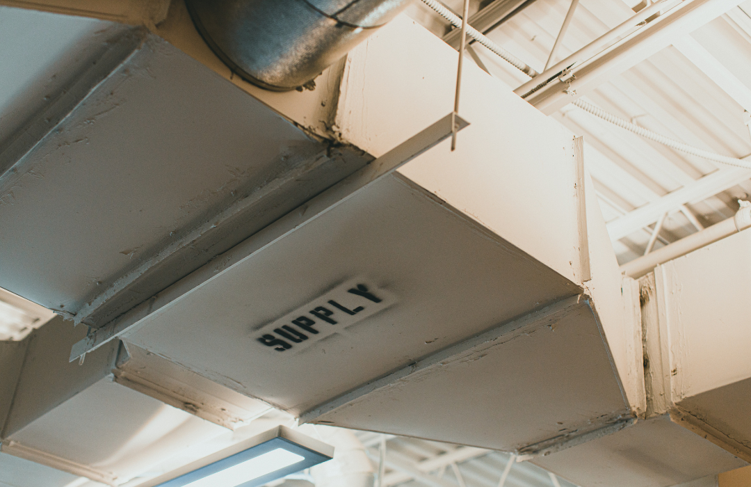 A supply duct is hanging from the ceiling of a building.