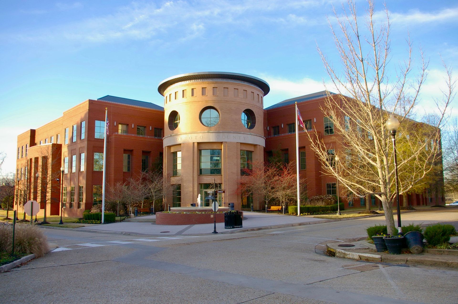 A large brick building with a fountain in front of it