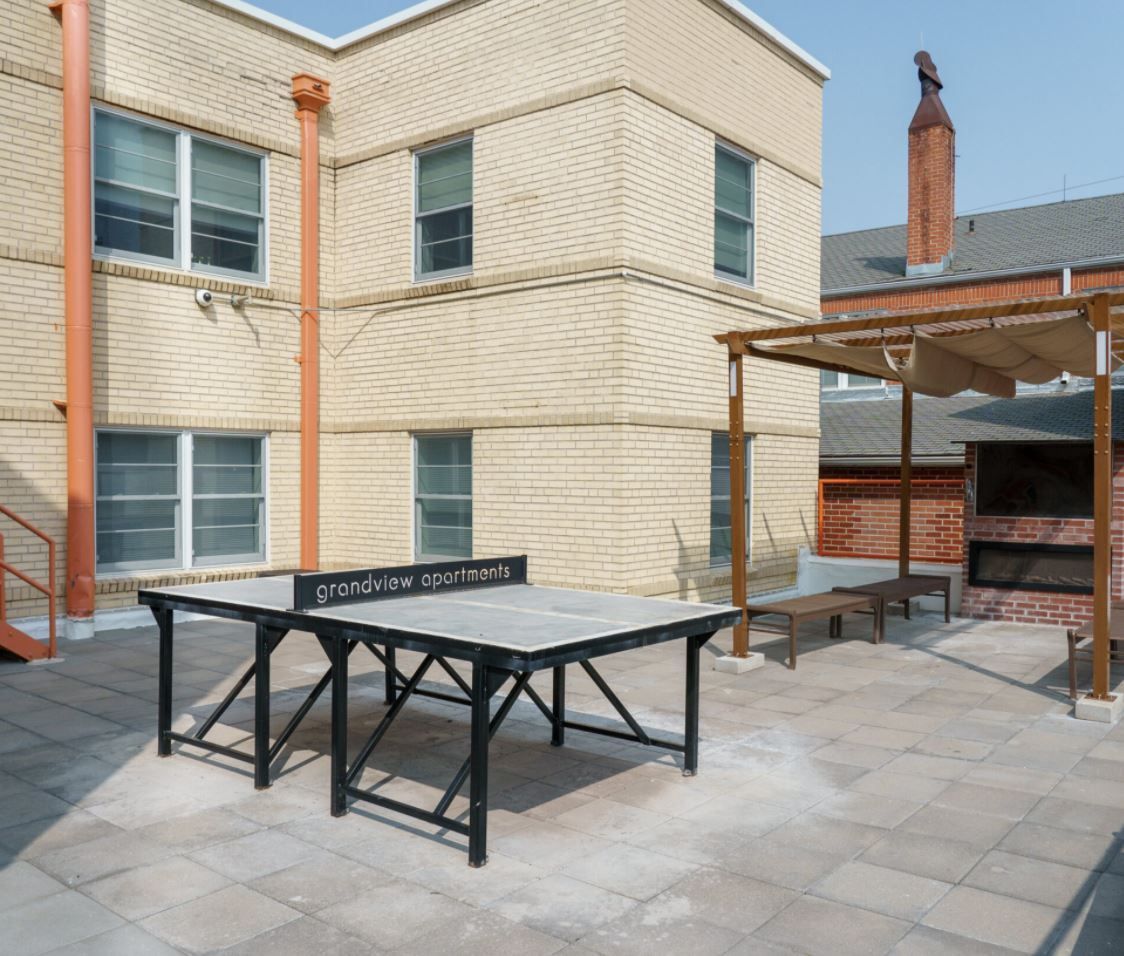 A ping pong table in front of a brick building