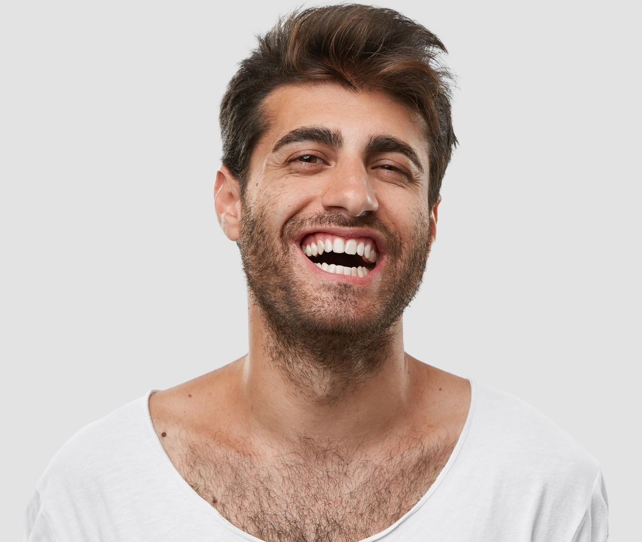 Un uomo con la barba ride e indossa una camicia bianca. - Arte Dentale Frosinone