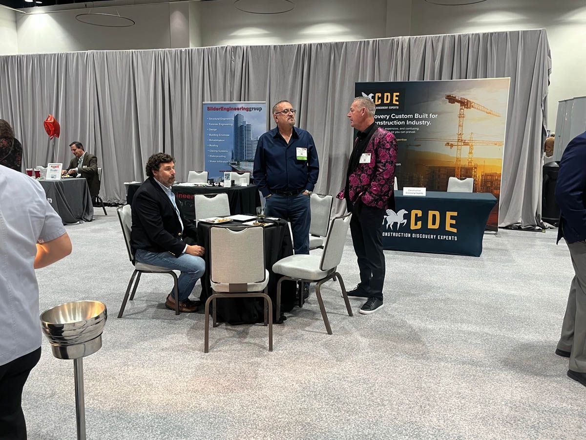 A group of men are standing around a table in a conference room.