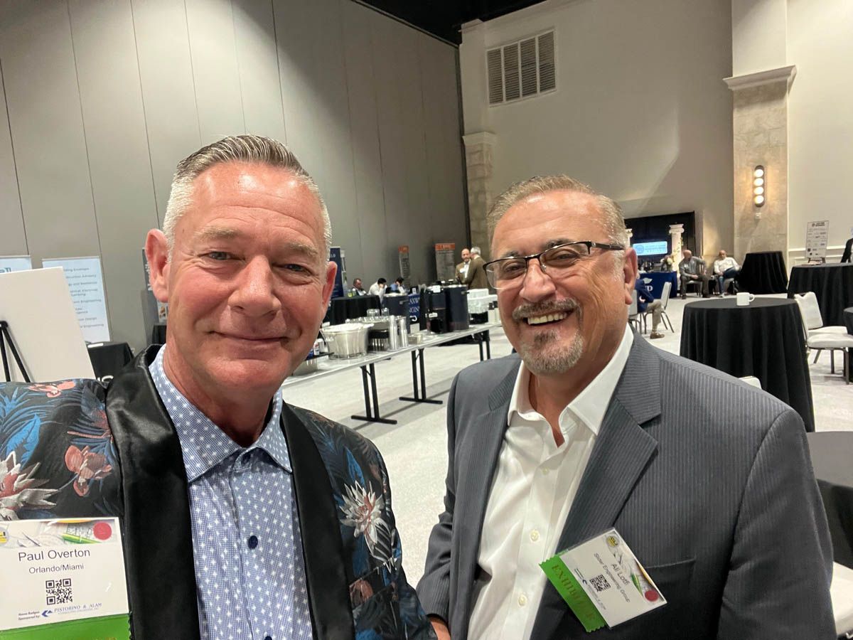 Two men are posing for a picture in a conference room.