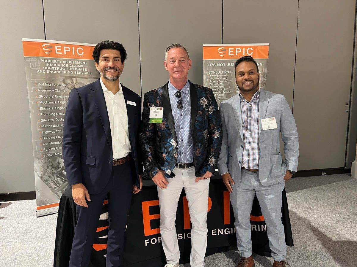 Three men are standing next to each other in front of a table.