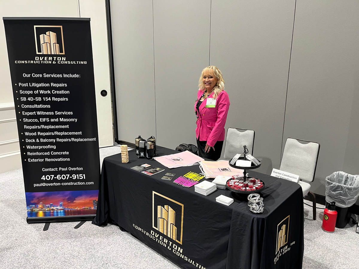 A woman is standing at a table with a microphone.