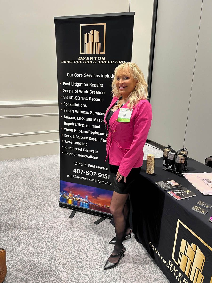 A woman in a pink jacket is standing in front of a sign that says spectrum.