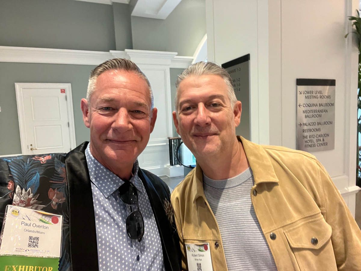 Two men are posing for a picture together in a room.