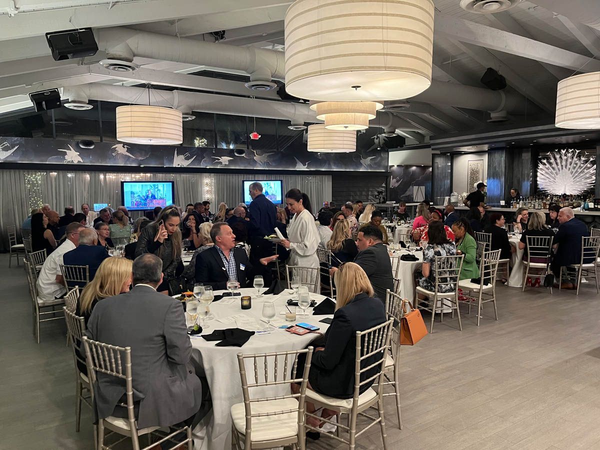 A large group of people are sitting at tables in a large room.