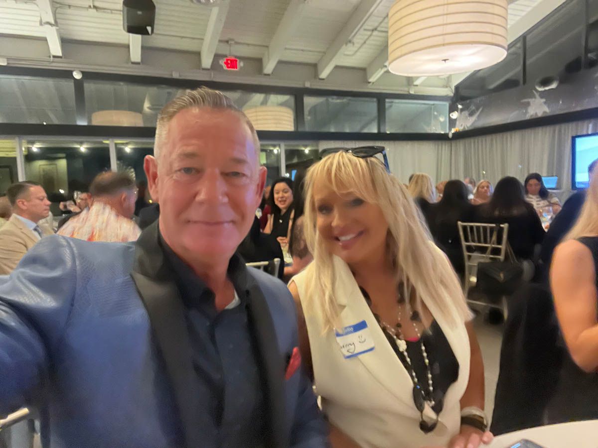 A man and a woman are posing for a picture at a party.