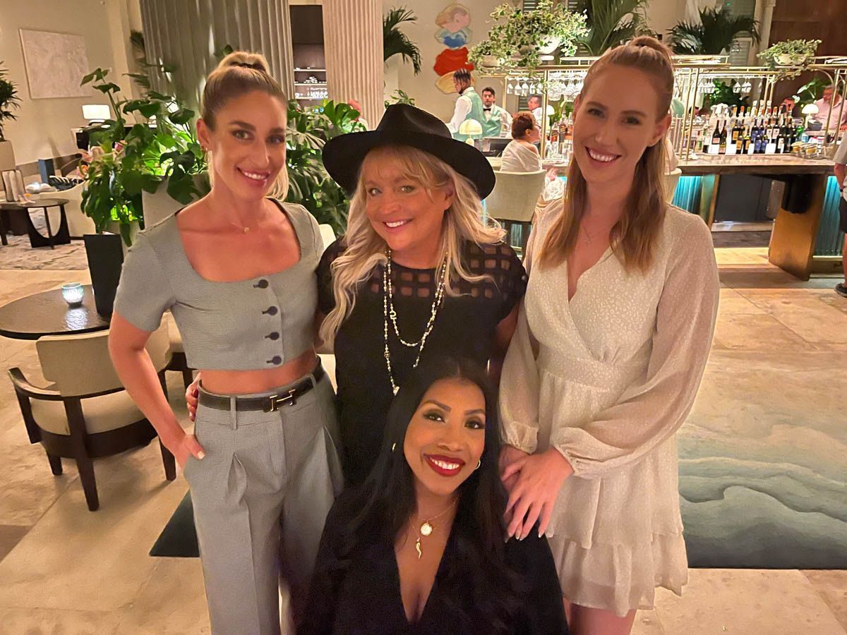 A group of women are posing for a picture together in a room.