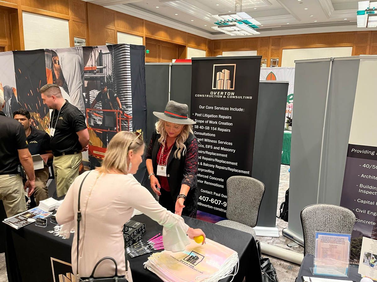 A group of people are standing around a table at a convention.