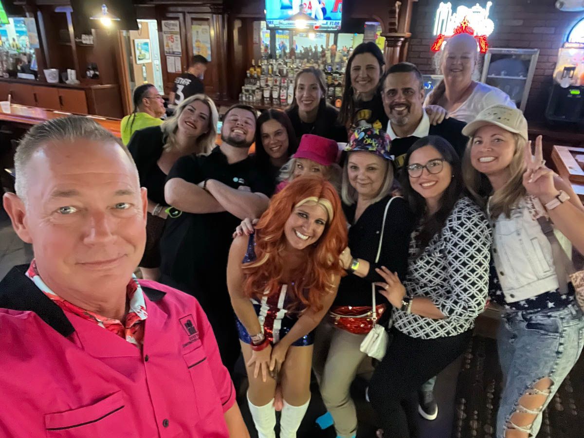 A group of people are posing for a picture in a bar.