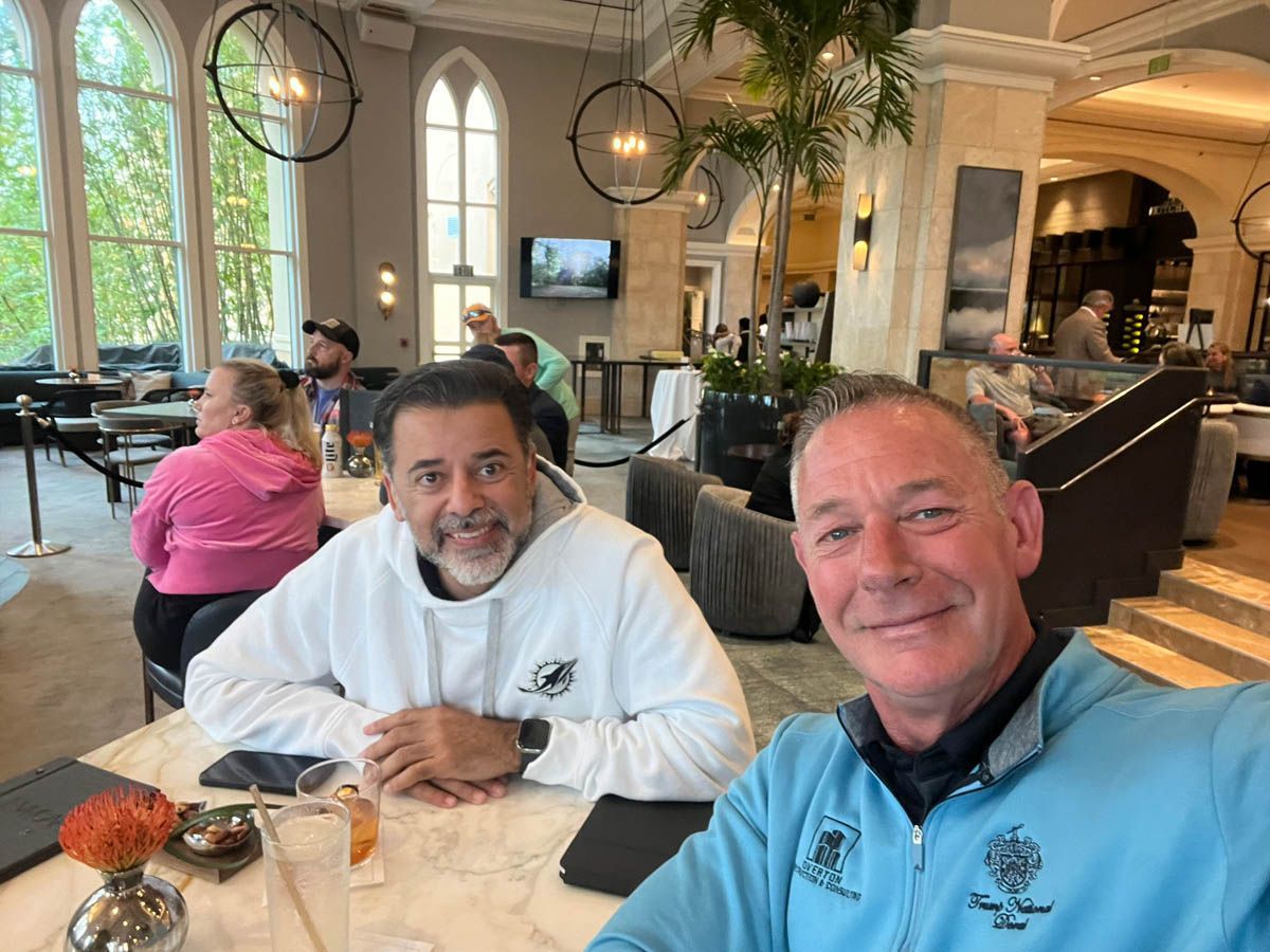 Two men are sitting at a table in a restaurant.