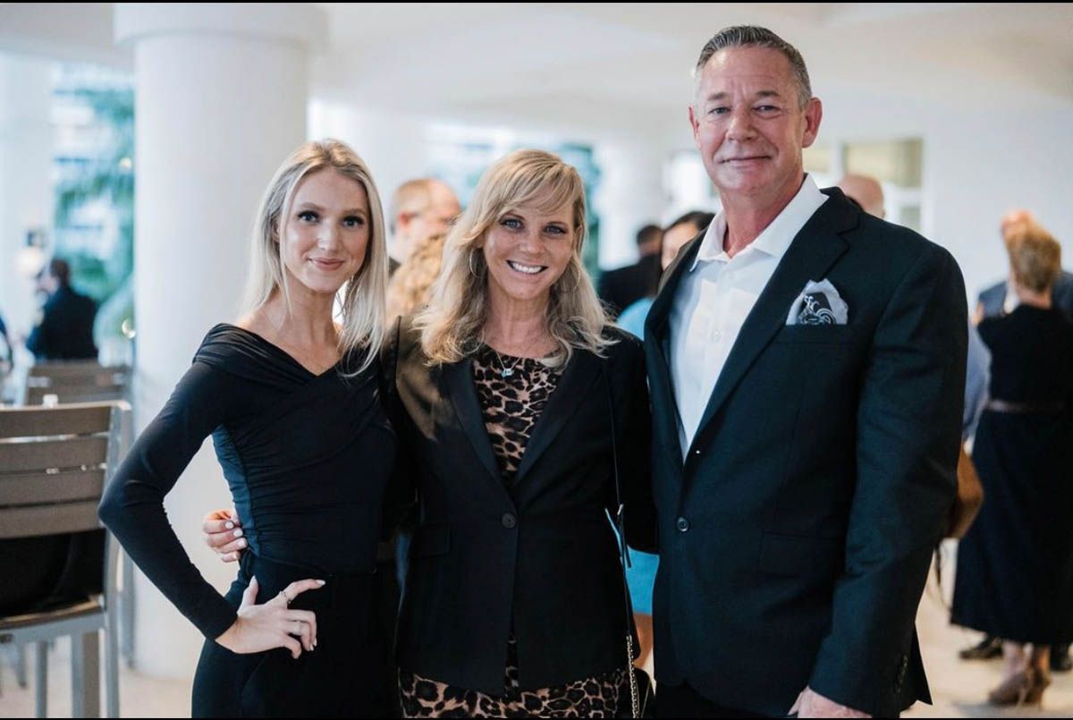 A man and two women are posing for a picture together.