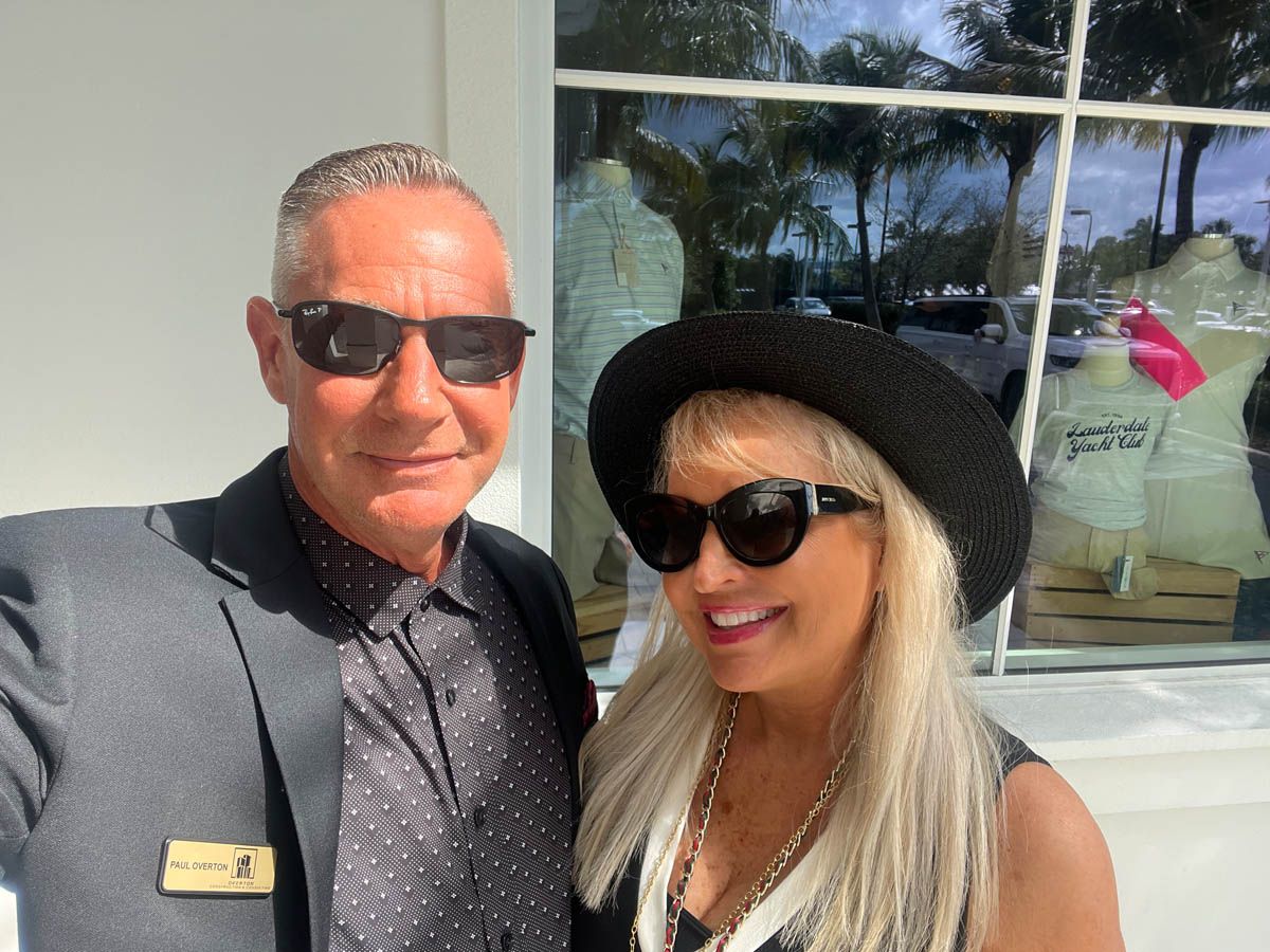 A man and a woman are posing for a picture in front of a window.