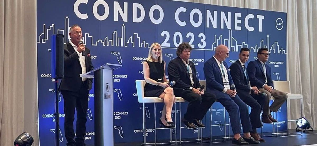 A group of people are sitting on a stage at a condo connect event.
