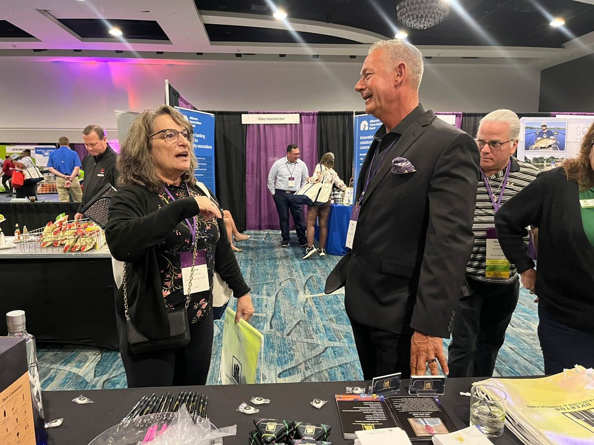 A group of people are standing around a table talking to each other.