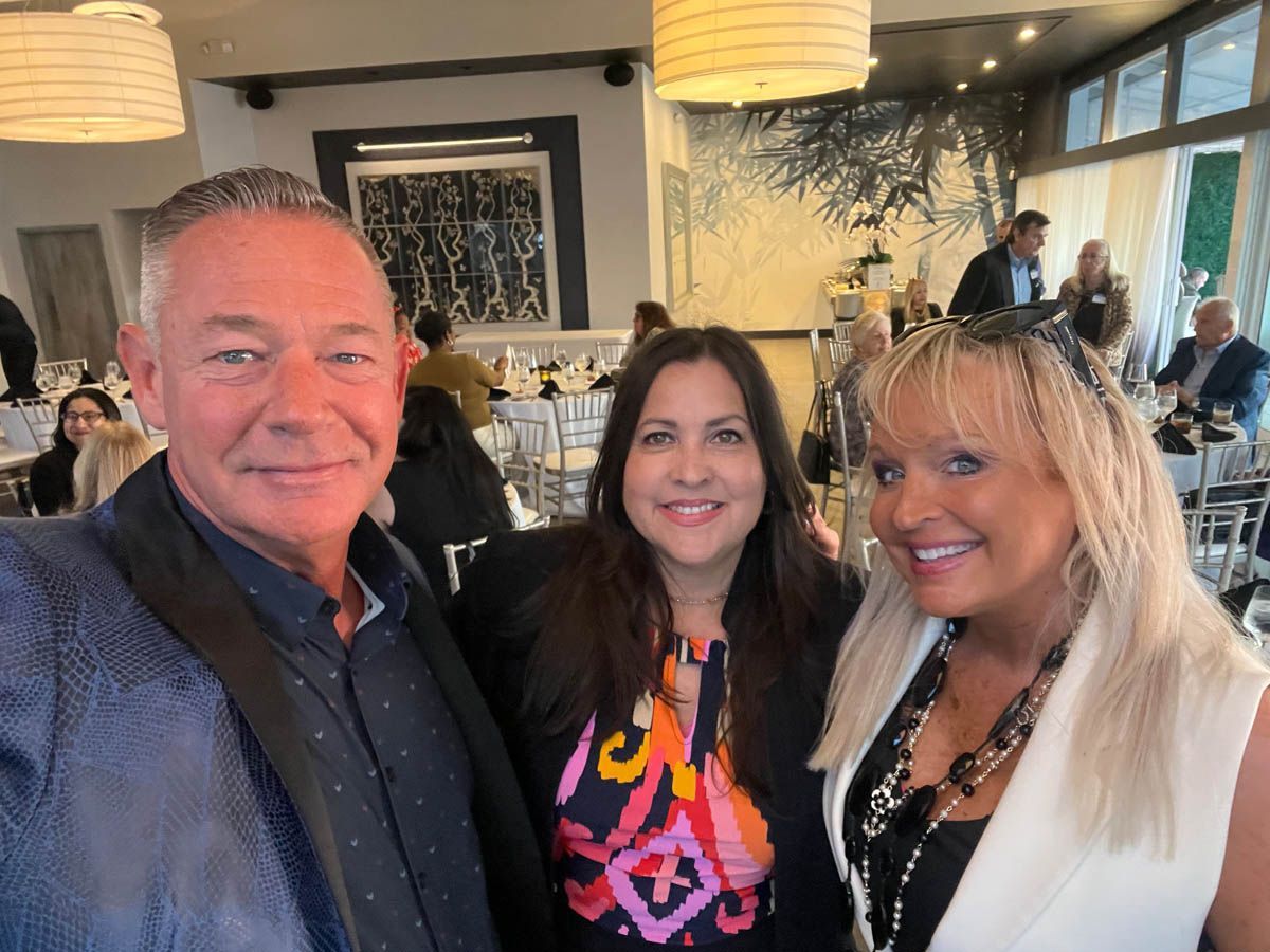 A man and two women are posing for a picture in a restaurant.
