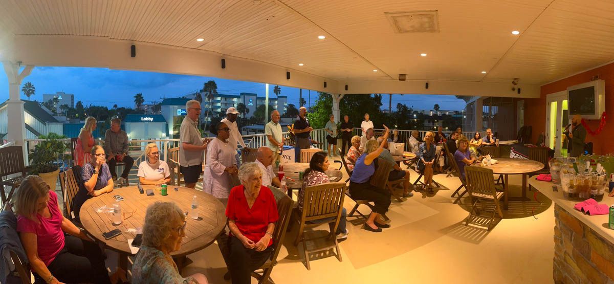 A large group of people are sitting at tables in a restaurant.