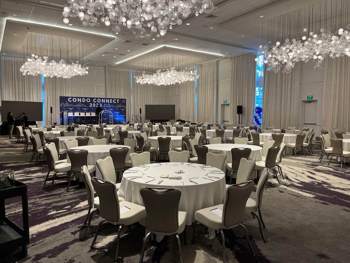 A large room with tables and chairs set up for a banquet.