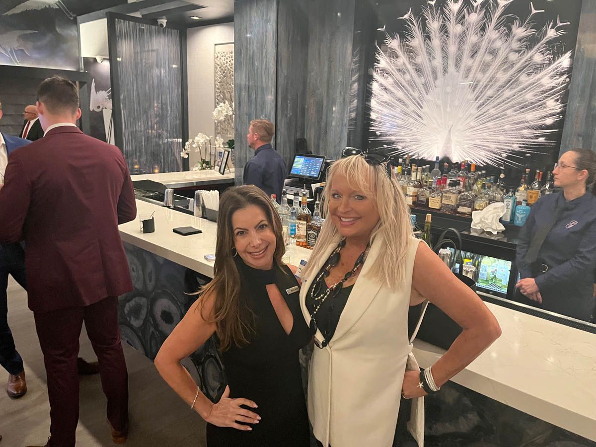 Two women are posing for a picture in a bar.