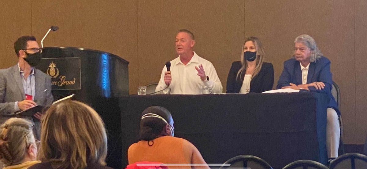 A group of people are sitting at a table in front of a podium.
